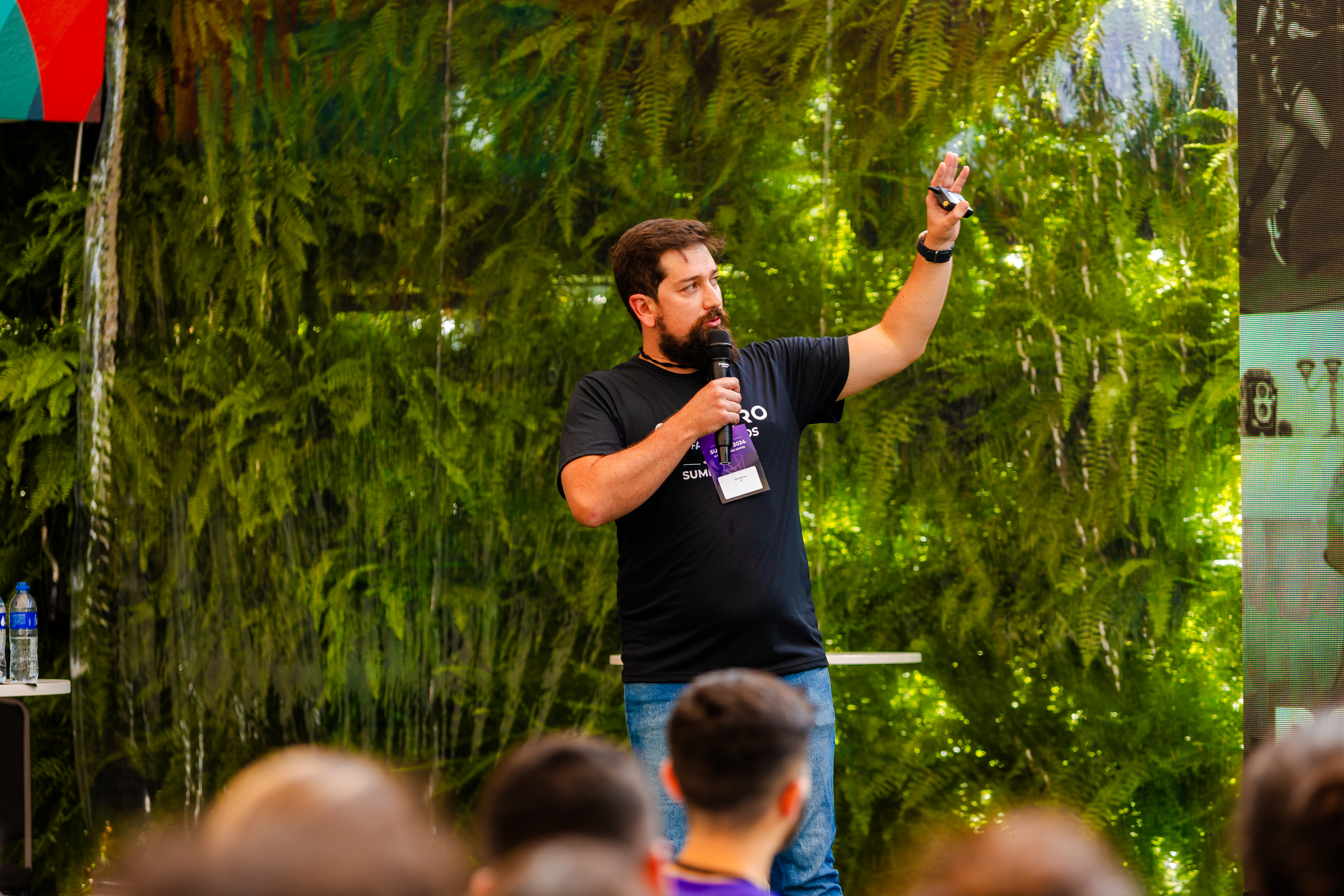 Enio Moraes palestrando em evento com fundo verde